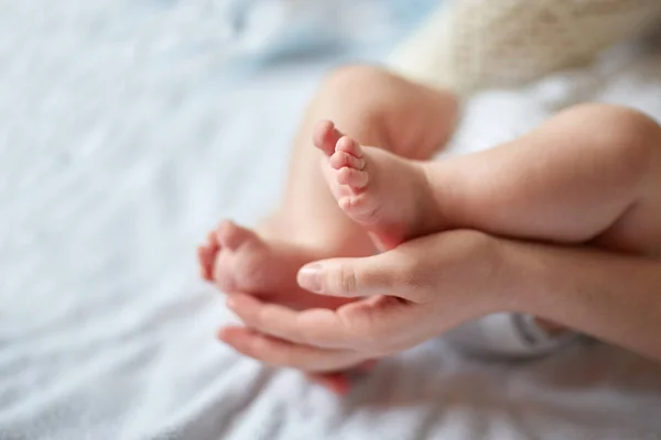 Moeders handen zorgvuldig houden van babys voet met tederheid — Stockfoto