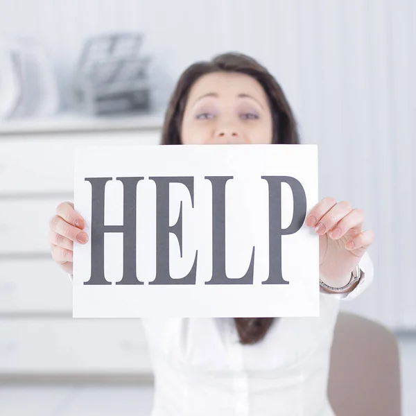 Lächelnde Geschäftsfrau zeigt ein Blatt mit dem Wort Hilfe — Stockfoto
