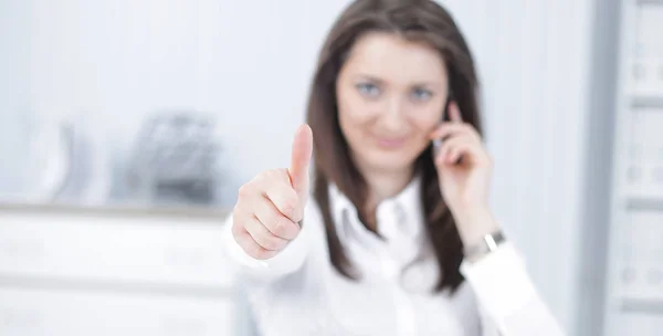 Employee of the company showing thumb up in the workplace — Stock Photo, Image