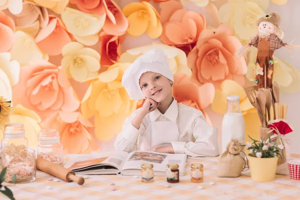 Chef niño feliz de pie cerca de la mesa de la cocina —  Fotos de Stock