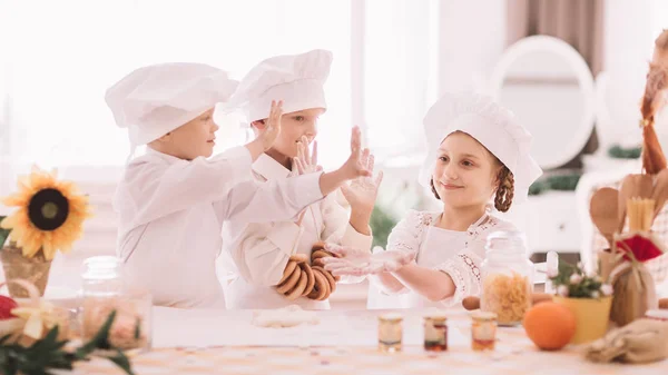 Bambini in uniforme da chef che si danno un cinque alto — Foto Stock