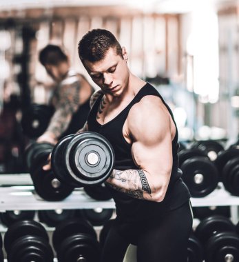 vücut geliştirmeci dumbbells ile egzersizler gerçekleştirir .fotokopi alanı ile fotoğraf