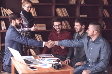 Ofisteki bir toplantıda iki tasarımcının el sıkışması.