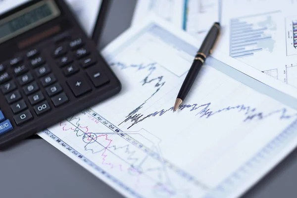 Close up.pen, grafico finanziario e calcolatrice sulla scrivania degli uomini d'affari — Foto Stock