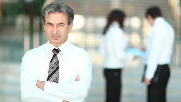 Portrait of a senior businessman on blurred background office — Stock Photo, Image