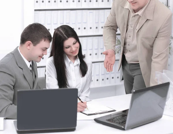 Business team discussing business issues, sitting behind a Desk — стоковое фото