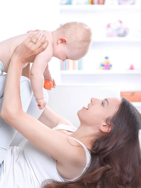 Mãe brinca com bebê no sofá — Fotografia de Stock