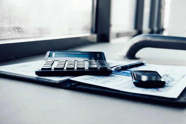 Taschenrechner, Smartphone und Finanzunterlagen auf dem Schreibtisch — Stockfoto