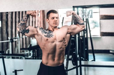 spor salonunda poz kaslı genç adam .