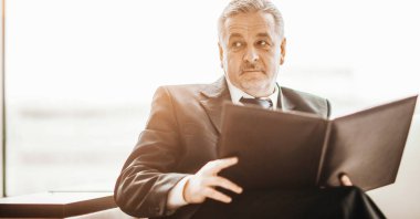 başarılı işadamı kanepede oturan çalışma kağıtları çalışmaları