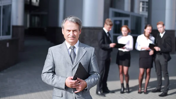 Erfolgreicher Geschäftsmann vor dem Hintergrund von Bürogebäuden . — Stockfoto