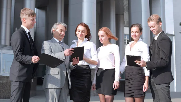 Professionele groep van zakenlieden bespreekt het papier in de buurt van het moderne kantoorgebouw — Stockfoto