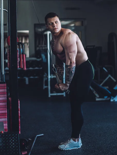Kas vücut geliştirmeci triceps pompalamak için bir eğitmen kullanır — Stok fotoğraf
