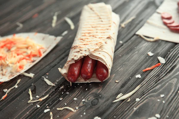 Pita ekmeği ahşap bir masa üzerinde baharatlı sosisler — Stok fotoğraf