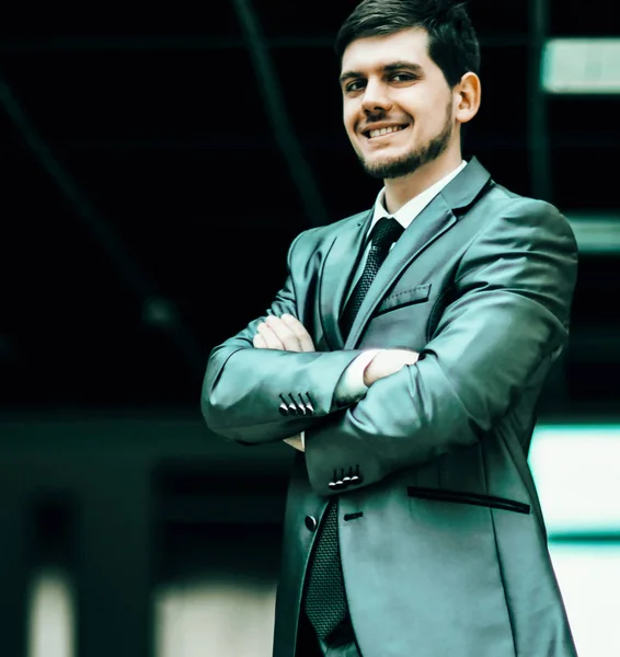 Porträt eines lächelnden gutaussehenden Geschäftsmannes auf Bürohintergrund — Stockfoto