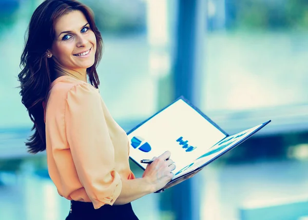 Attractive modern young business woman with a folder in his hand — Stock Photo, Image