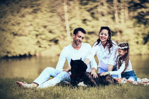 Happy father of a daughter and a pregnant mom at a picnic. — Stock Photo, Image