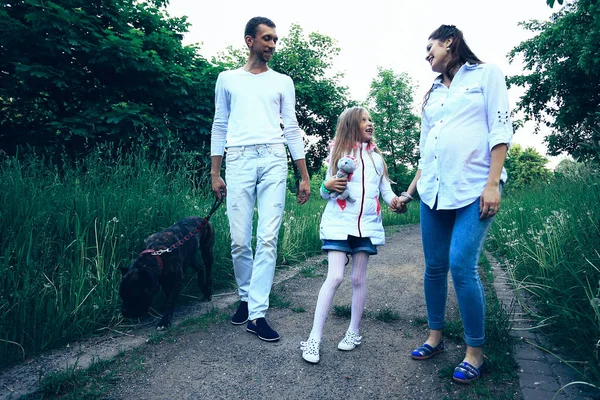 Kleines Mädchen mit ihren Eltern und Hund im Park — Stockfoto