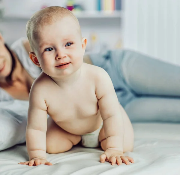 Retrato de madre feliz y bebé de un año en la cama en la cama —  Fotos de Stock