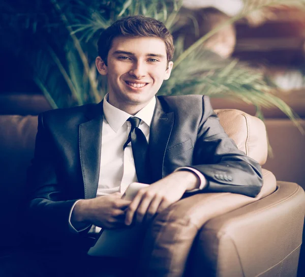 Relaxed businessman sitting in front of the Windows of the offic — Stock Photo, Image