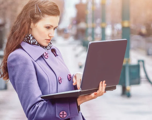 Mooi meisje met een laptop buiten op een zonnige dag — Stockfoto