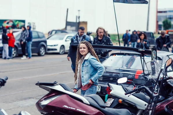 Weißrussland, Minsk, 17. Mai 2015, Oktyabrskaja Straße, Radfahrerfest. Hübsches Mädchen steht neben einem Motorrad auf dem Stadtparkplatz — Stockfoto