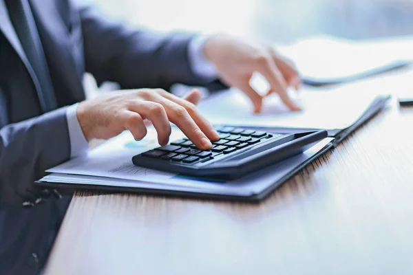 Close up. businessman checks the financial data with calculator — Stock Photo, Image