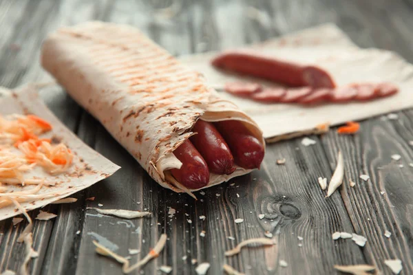 Pita ekmeği ahşap bir masa üzerinde baharatlı sosisler — Stok fotoğraf