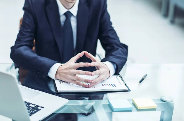 Empresário de sucesso está considerando a política financeira da empresa sentada atrás de uma mesa — Fotografia de Stock