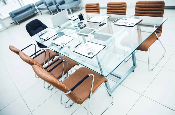 Mesa para negociações com os gráficos financeiros preparados e equipamentos de escritório na sala de conferências antes de reuniões de negócios . — Fotografia de Stock