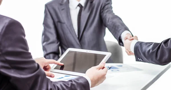 businessman with digital tablet on background of business partners handshaking