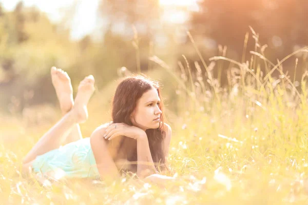 Krásná mladá žena ležela v létě na trávě, s prostorem pro kopírování textu — Stock fotografie