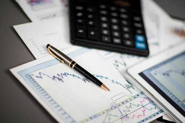 Tablet, calculadora, caneta e gráficos financeiros no empresário local de trabalho — Fotografia de Stock