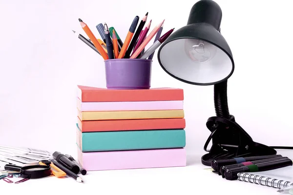 Lampada da tavolo e colorato materiale scolastico su sfondo bianco .photo con spazio copia — Foto Stock