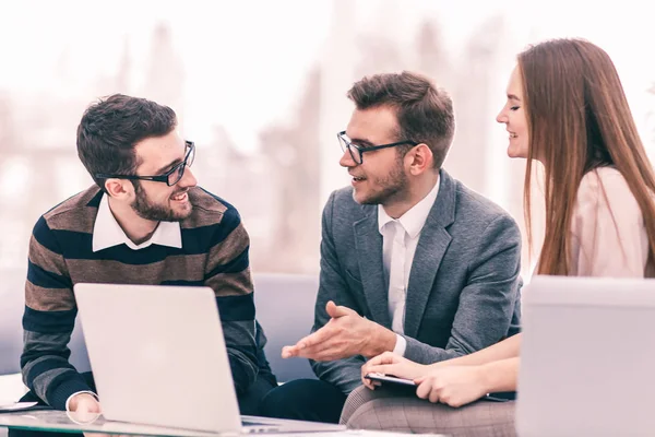 Manager des Unternehmens und des Kunden diskutieren die Bedingungen des neuen Vertrages und schauen auf den Laptop-Bildschirm mit den korrekten Informationen. — Stockfoto