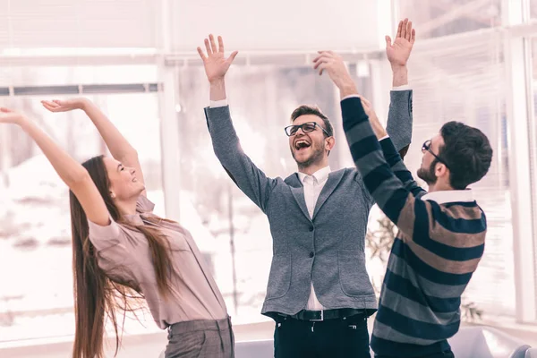 Conceito de vitória - a equipe de negócios jubilosa que está em um círculo, entrega-se no êxito de alegria . Imagem De Stock