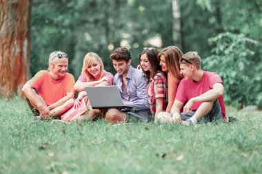 bir grup öğrenci ile laptop bir Sunny Park'ta rahatlatıcı 