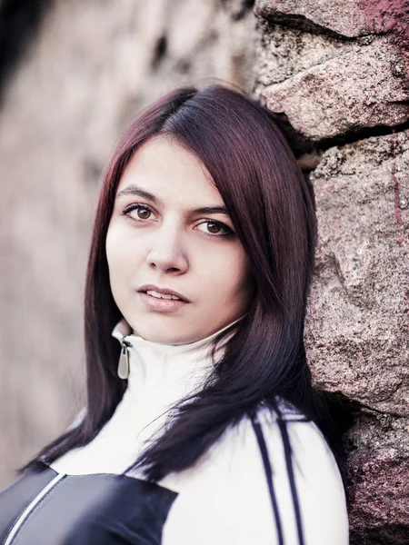 Portret van een mooie jonge vrouw op stenen muur achtergrond — Stockfoto