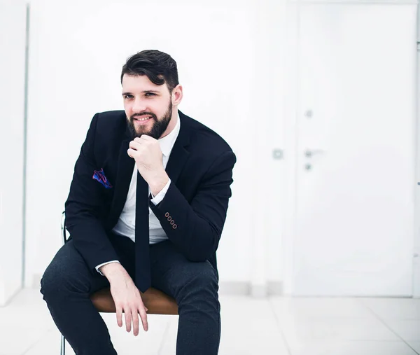 Exitoso hombre de negocios en un traje de negocios sentado en la silla de oficina — Foto de Stock