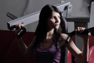 Kuvvet treynerler, sıra sıkıştırma göğüs egzersiz genç kadın.