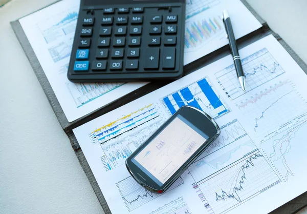 Calculatrice, smartphone et documents financiers sur l'entreprise — Photo