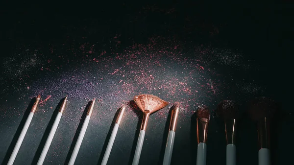 Conjunto de pinceles de maquillaje profesionales sobre fondo negro —  Fotos de Stock