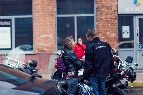 Belarús, Minsk, 17 de mayo de 2015, calle Oktyabrskaya, festival de motociclistas. pares de ciclistas de pie cerca de motocicletas en una calle de la ciudad . — Foto de Stock