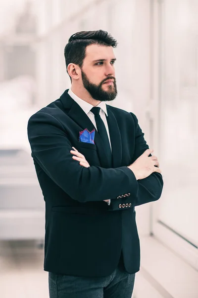 Erfolgreicher Geschäftsmann steht in hellem Büro am Fenster. — Stockfoto