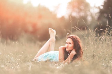 Güzel genç kadın yaz Park çimenlerin üzerinde