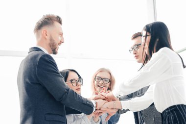 İş adamları ofiste dikilirken birliklerini gösteriyorlar.