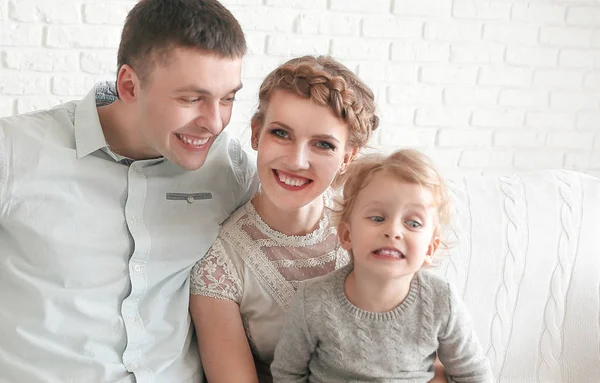 Šťastná rodina s malou dcerou sedí na pohovce — Stock fotografie