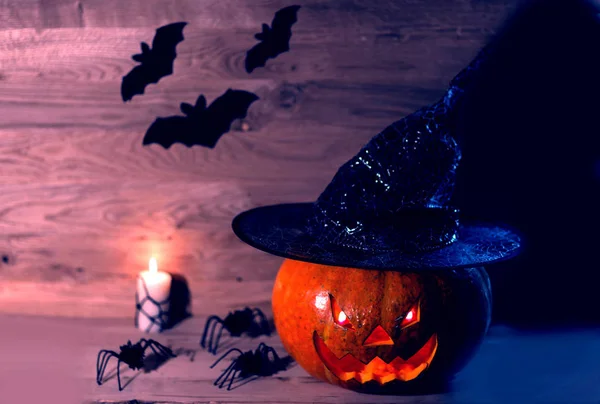 Жуткая тыква на Хэллоуин в шапке ведьмы на деревянном фоне — стоковое фото