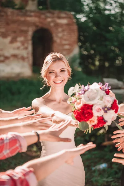 Усміхнена наречена дарує весільний букет своїм друзям . — стокове фото