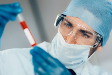 Kapat. Laboratuvar asistanının ellerinde test tüpü..